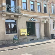 Elbbikes Fahrradladen in Pirna Fahrradgeschäft "ElbBikes" in einem historischen Gebäude mit gelbem Automaten und Werbeschild für Fahrradservice vor dem Schaufenster.