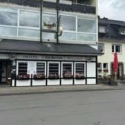Hotel-Restaurant Zum Holländer - Außenansicht Hotel und Restaurant mit schwarzen Fensterläden und bunten Blumenkästen, angrenzendem Außenbereich.