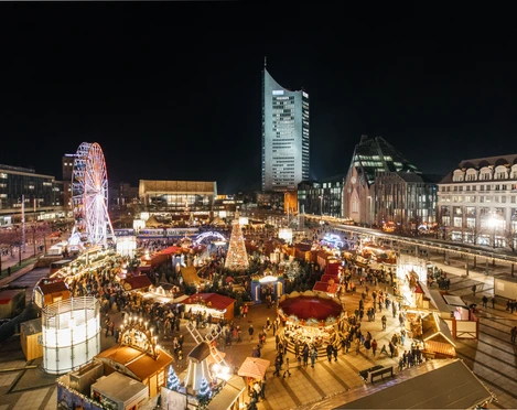 Weihnachtsmarkt auf dem Augustusplatz - Weihnachten in Leipzig Blick auf den hell erleuchteten Augustusplatz mit dem Märchenwald und Riesenrad am Abend mit dem Gewandhaus und City-Hochhaus im Hintergrund