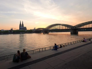 Rheinboulevard Atemberaubendes Panorama bei Sonnenuntergang: Blick auf den Rhein, die Kölner Domspitzen und die Hohenzollernbrücke.Breathtaking panorama at sunset: view of the Rhine, the spires of Cologne Cathedral and the Hohenzollern Bridge.