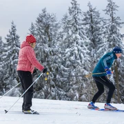 Langläufer-Paar auf der Abfahrt in der Loipe Langläufer-Paar auf der Abfahrt in der Loipe