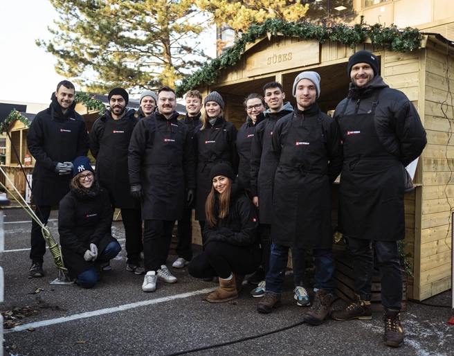 fabian stuertz 2022.12.15 - street kitchen 0005.jpg Teamfoto von Street-Kitchen Catering vor Holzständen für einen WeihnachtsmarktTeam photo of Street-Kitchen Catering in front of wooden stalls for a Christmas market
