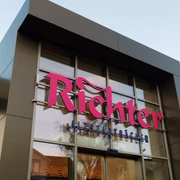 Eingang BACK.HAUS Nahaufnahme einer eckigen Fassade mit großen Glasflächen. Pinke Aufschrift: "Richter" darunter in blau: "Altstadtbäcker"