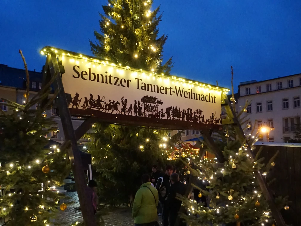 Tannertweihnacht Sebnitz Glänzende Lichterketten schmücken einen großen Weihnachtsbaum auf dem Sebnitzer Tannertweihnachtsmarkt.