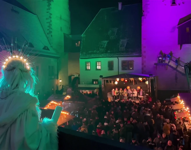 Rochlitzer Schlossweihnacht Zusehen ist der Innenhof von Schloss Rochlitz mit der Schlossweihnacht. Am Bildrand ist ein Engel.