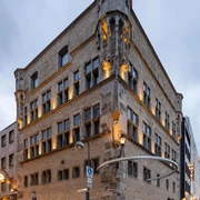 Saaleck House, artothek Historisches Gebäude mit verzierten Ecktürmen, mehrstöckigen Fenstern und Abendbeleuchtung.Historic building with ornate corner towers, multi-storey windows and evening lighting.