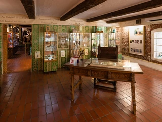 Farina Fragrance Museum Das Bild zeigt ein historisches Museum mit antiker Inneneinrichtung, grünen Fliesen und Glasschränken.The picture shows a historical museum with antique interior design, green tiles and glass cabinets.