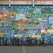 Mural Buntes Mural mit vielen fröhlich gezeichneten Autos, darunter parkende Fahrräder.Colorful mural with lots of cheerfully drawn cars, including parked bicycles.