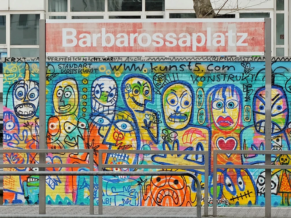 Mural Das Bild zeigt eine bunte Wand voller fantasievoller Graffiti-Figuren am Barbarossaplatz in Köln.The picture shows a colorful wall full of imaginative graffiti figures at Barbarossaplatz in Cologne.