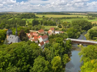Ansicht von Wünschendorf mit der Veitskirche und Holzbrücke