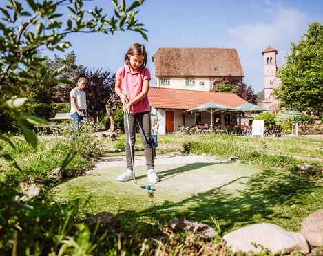 Eine Familie spielt Minigolf in Klosterreichenbach