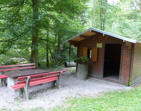 Eine Holzhütte schützt beim Grillen vor Sonne, Regen und Wind.