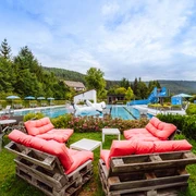 Übersicht über das Freibad mit Sitzecke, Rutsche und Spieltier