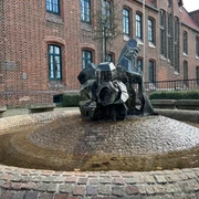 Im Herzen einer Backsteingebäudekulisse thront der Zwergenbrunnen mit modernen skulpturalen Formen.