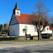 Die Heilig-Kreuz-Kapelle Haldem hat ein rotes Ziegeldach und Fachwerkelemente an den Giebelseiten.