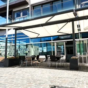 Hafenterrasse (Weitansicht) Terrasse mit Sitzgelegenheiten und SonnensegelTerrace with seating and awning