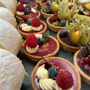 Sweet Cologne Eine köstliche Auswahl bunter Törtchen und süßer Gebäcke, verziert mit frischen Beeren.A delicious selection of colorful tarts and sweet pastries, decorated with fresh berries.