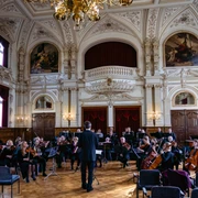 Schlossorchester Oldenburg Opulenter Saal mit dekorativen Deckenverzierungen, in dem Schlossorchester Oldenburg probt.