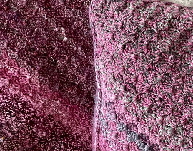 Gehäkeltes Stoffkissen Gehäkeltes Kissen und Decke in Rosa- und Lilatönen mit dichter, strukturierter Wolloberfläche