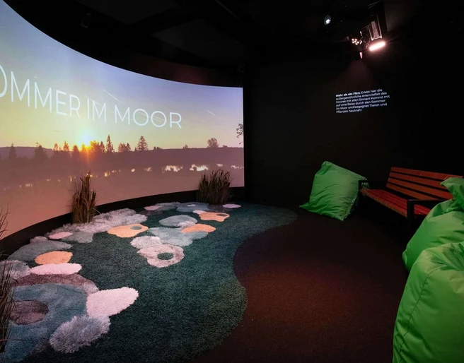 Moorerlebniswelt-Bad-Driburg-Kabinette_82.jpg Kinoraum in der Moorerlebniswelt mit Leinwand und Sitzecke.