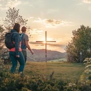 Wanderpaar am Gipfelkreuz auf dem Orenberg Wanderpaar am Gipfelkreuz auf dem Orenberg