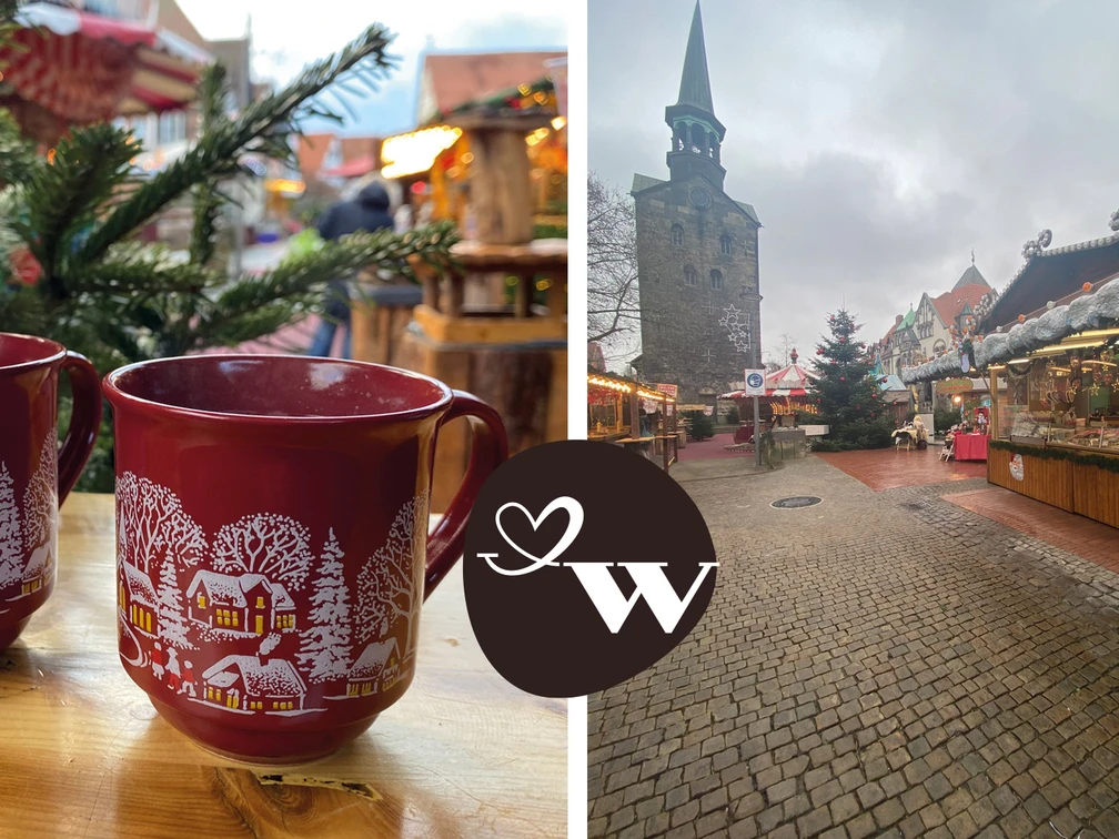 WGW Weihnachtsmarkt Zwei rote Tassen mit winterlichem Motiv auf einem Weihnachtsmarkt vor einer Kirche im Hintergrund.