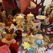 Foto 1 ArtD_ Weihnachtsecke.jpeg Verschiedene Weihnachtsdekorationen, darunter Engelsfiguren, ein rotes Rentier und festliche Kerzen.