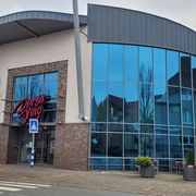 Dersa Kino Rahden Dersa Kino Rahden mit moderner Glasfassade, Eingangsbereich und Außenbestuhlung vor dem Gebäude.