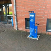 Radstation Hoyerhagen Die Radstation in Hoyerhagen bietet eine blaue Reparatursäule inklusive Luftpumpen an einer Backsteinmauer.