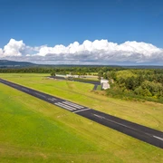 Höxter-Flugplatz Höxter-Holzminden-Teutoburger-Wald-Stadt Höxter-D-Ketz-044.jpg Luftbild der Start- und Landebahn umgeben von gemähter Wiese und Landschaft mit Flughafengebäude und Hangar rechts im BildAerial view of the runway surrounded by mown meadow and landscape with airport building and hangar on the right of the picture