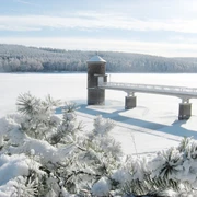 Verschneite Wasserfläche der Talsperre Cranzahl mit Turm