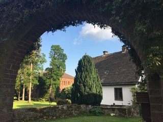 Godelheim_Maygadessen-Torbogen.JPG Blick durch einen Steinbogen auf Häuser der Gutshofanlage Maygadessen