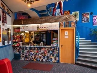 Filmpalast: Kasse Kassenbereich des Kinos, überall hängen Filmplakate.