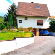 Außenansicht Haus Feicke mit Zufahrt und Garage und Sicht auf den Garten