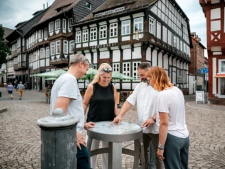 Einbecker Bierpfad Vier Personen betrachten ein Fass des Bierpfades auf dem Einbecker Marktplatz.