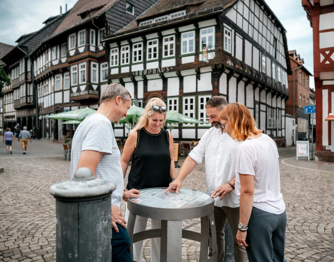 Einbecker Bierpfad Vier Personen betrachten ein Fass des Bierpfades auf dem Einbecker Marktplatz.