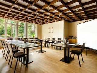 Raum mit Blick ins Grüne Konferenzraum mit U-Form Bestuhlung, Leinwand und Blick in die NaturConference room with U-shaped seating, screen and view of nature