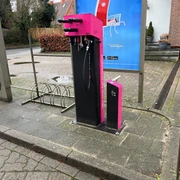 Rad-Servicestation Kirchlinteln Rad-Servicestation mit Werkzeugen und Luftpumpe auf Gehweg. Hintergrund: Straßenszene, Gebäude.