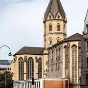 St. Andrew Sankt Andreas erhebt sich eindrucksvoll mit ihrem gotischen Turm und den charakteristischen Bogenfenstern über das Kölner Stadtbild.St. Andrew's rises impressively above the Cologne cityscape with its Gothic tower and characteristic arched windows.