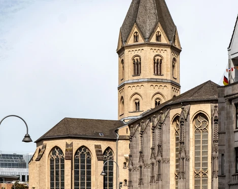 St. Andrew Sankt Andreas erhebt sich eindrucksvoll mit ihrem gotischen Turm und den charakteristischen Bogenfenstern über das Kölner Stadtbild.St. Andrew's rises impressively above the Cologne cityscape with its Gothic tower and characteristic arched windows.