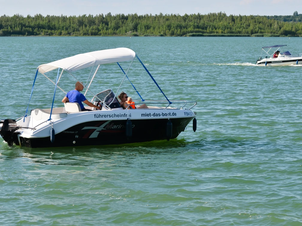 Führerscheinfreier Bootsverleih Störmthaler Hafen.jpg Das Bild zeigt zwei fahrende Boote auf dem Störmthaler See, worauf sich mehrere Personen befinden, ab. Auffällig ist das traumhafte Wetter, dass sich durch die klare Sicht, wolkenlosen Himmel und stralenden Sonnenschein auszeichnet. Die Boote sind mit der Aufschrift "führerscheinfrei" und "miet-das-boot.de" versehen und können am Störmthaler Hafen ausgeliehen werden.