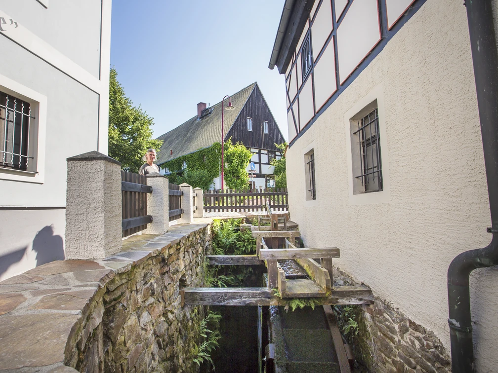 Wassermühle in Höfgen Fouad Vollmer Werbeagentur.jpg Das Bild zeigt die Wassermühle des Dorf Höfgen, die von Fachwerkhäusern und dem historischen Gasthaus eingerahmt wird