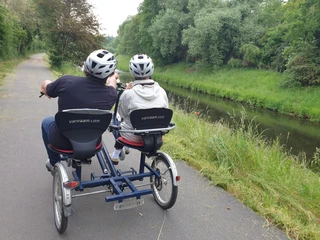 Mutter mit Tochter auf einem Rad für Menschen mit Behinderung