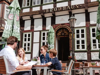 Familie beim Brodhaus Eine Familie mit zwei Kindern sitzt an einem Tisch vor dem Brodhaus.