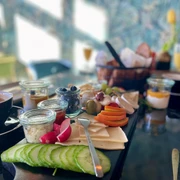 Frühstück_Richhome_@_CCBYSA_Teutoburger Wald_Stadt_Schloß Holte-Stukenbrock.jpg Frühstückstisch mit Kaffee, Käse, Gurken und Aufstrichen, Körbchen mit Brötchen im Hintergrund