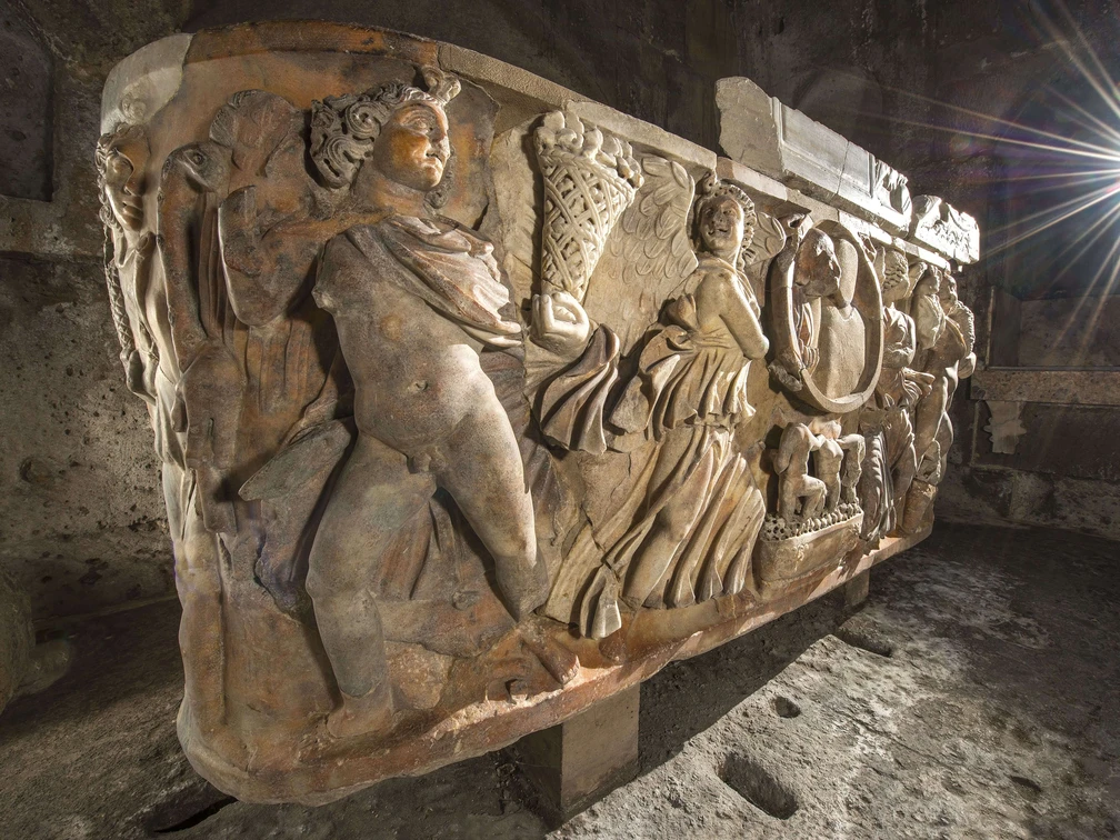 Roman sarcophagus in the Roman tomb in Cologne Weiden  Antiker Sarkophag mit kunstvollen Reliefs von Figuren und Szenen in einem steinernen Gewölbe.Ancient sarcophagus with artistic reliefs of figures and scenes in a stone vault.