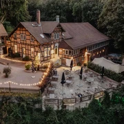 Luftaufnahme des beleuchteten PEAK Hotels in Abendstimmung mit vorgelagerter Aussichtsterrasse in Salzgitter-Lichtenberg