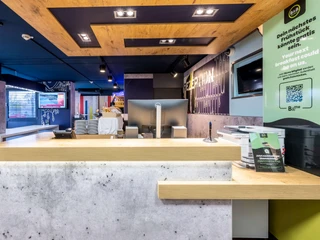 Rezeption im B&B HOTEL Düsseldorf-Hilden Empfangstresen des B&B HOTEL Düsseldorf-Hilden mit modernen Designelementen und heller Beleuchtung.