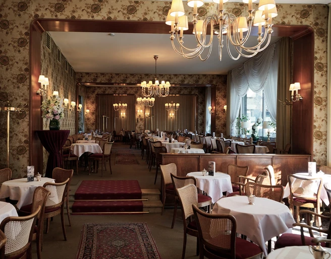 Cafe Wahlen Ein Café im 50er Jahre Stil mit Kronleuchtern und floralen Tapeten. A 50s-style café with chandeliers and floral wallpaper.
