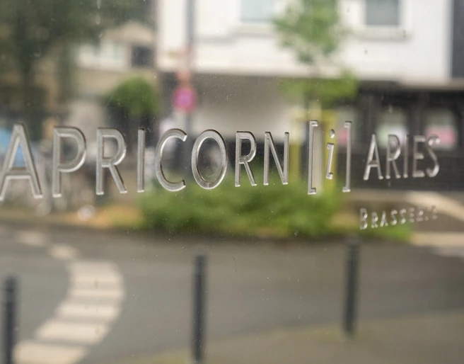 Brasserie Capricorn i aries  In großen Lettern steht der Restaurantname auf einem Schild.The restaurant's name is written in large letters on a sign.